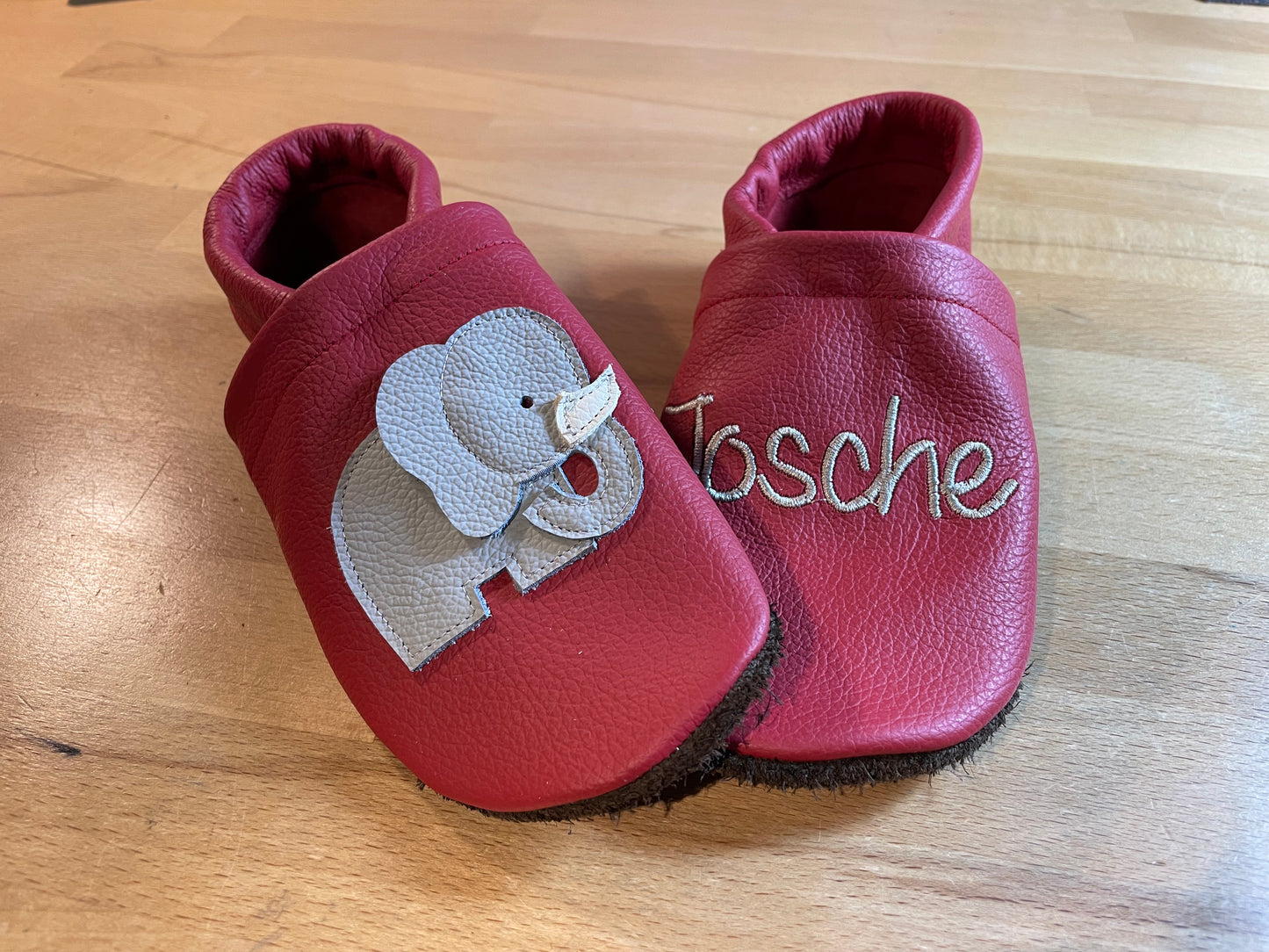 Rote Lederpuschen mit einem Elefanten und einem Namen