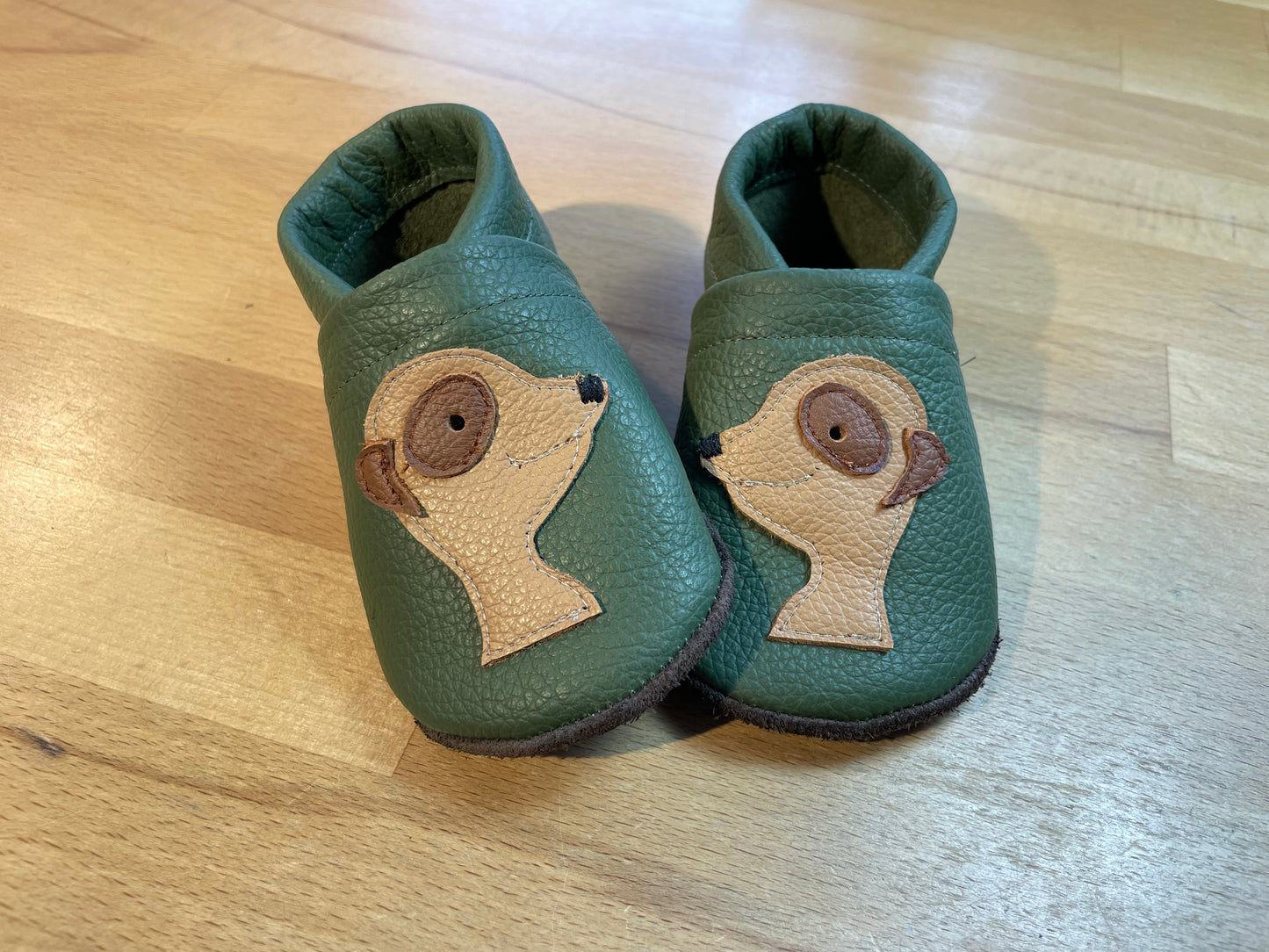 Olivgrüne Lederpuschen mit Erdmännchen