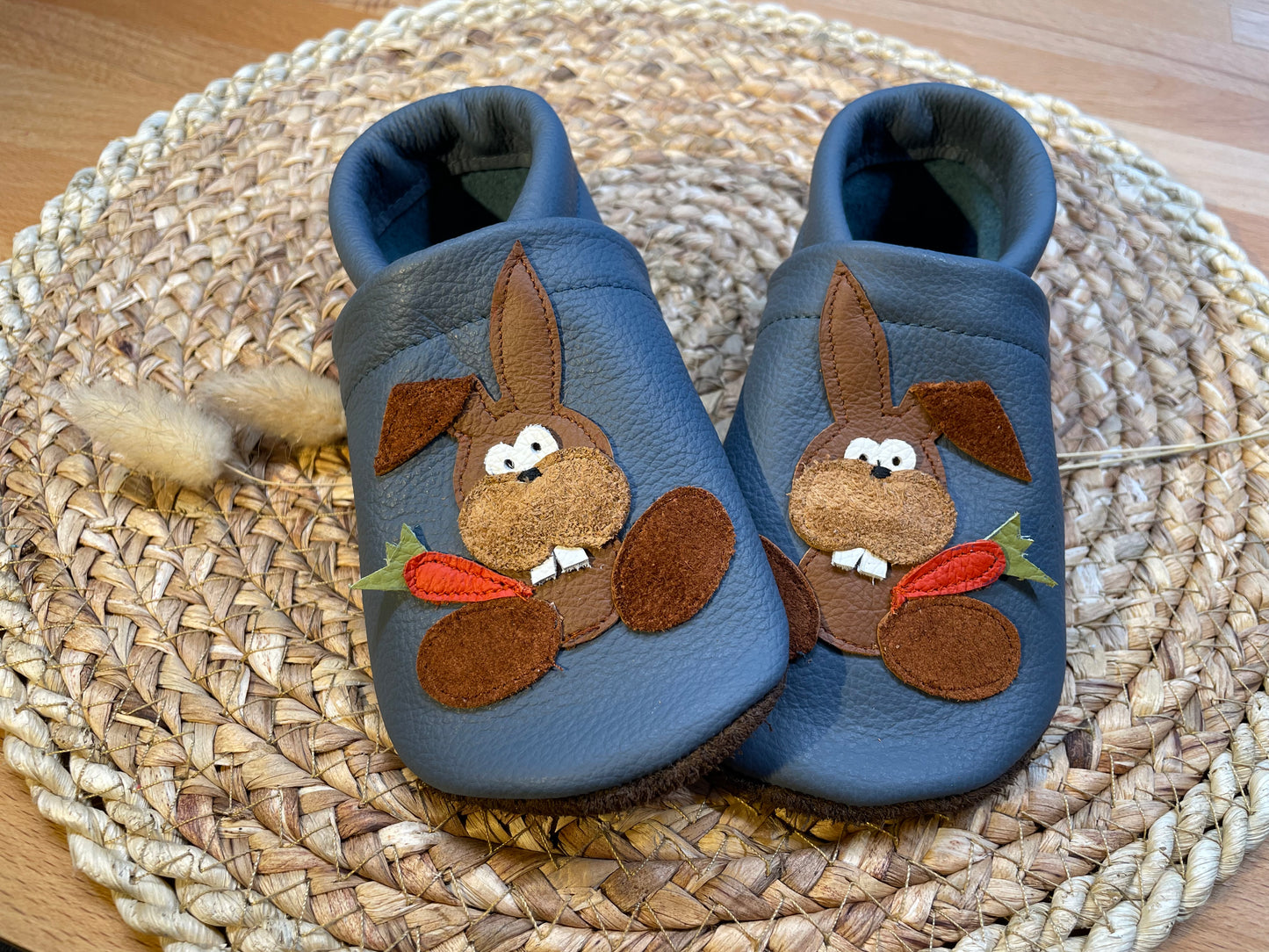 Taubenblaue Lederpuschen mit einem Hasen mit Möhre