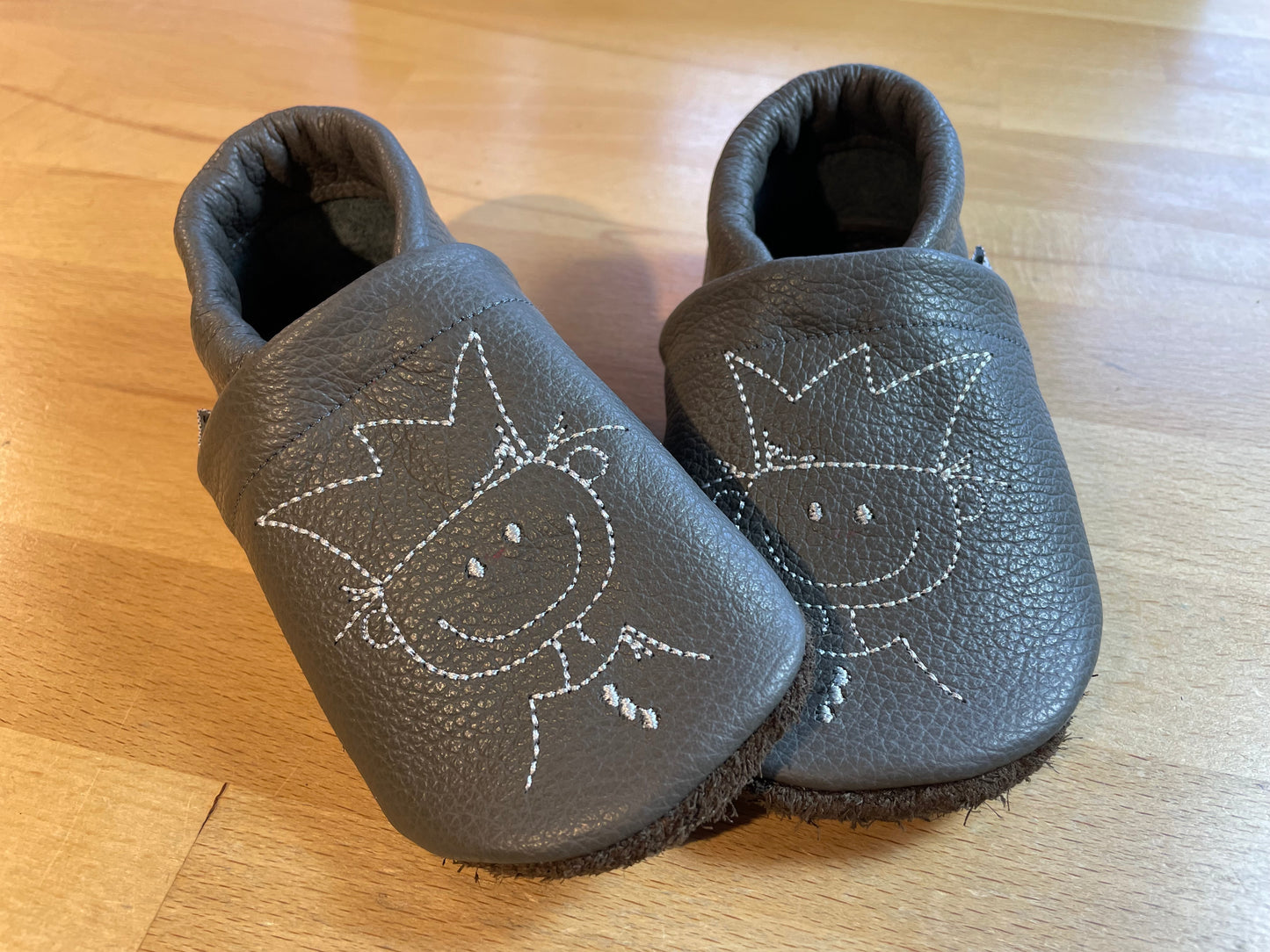 Dunkelgraue Lederpuschen mit Prinzen Stickmotiv