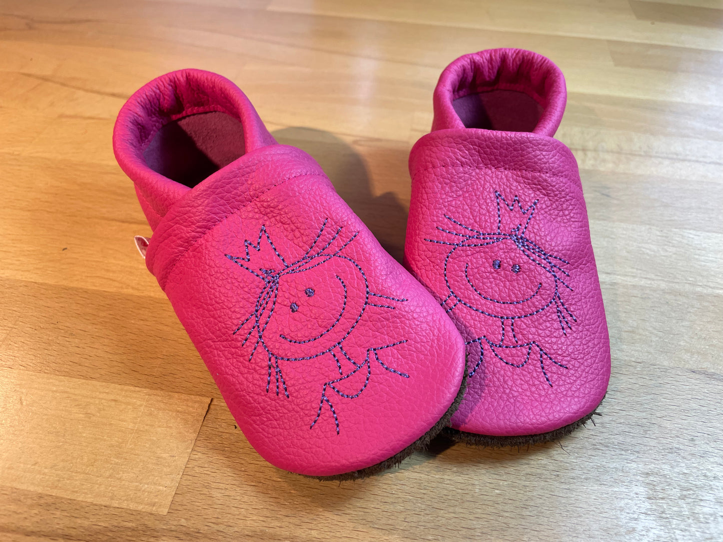 Pinkfarbene Lederpuschen mit einer Prinzessin Stickmotiv