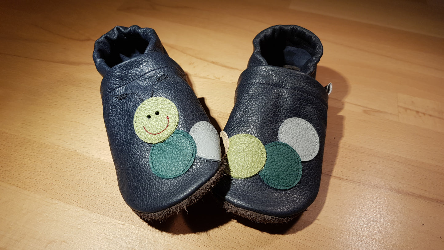 Dunkelblaue Lederpuschen mit einer Raupe