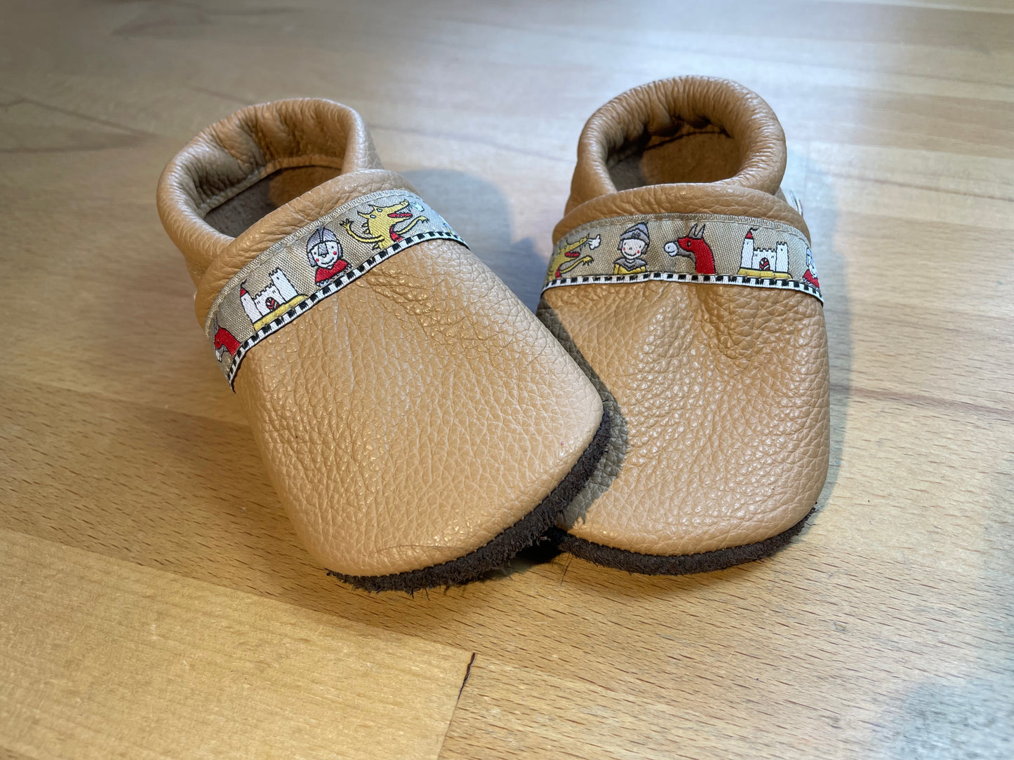 Camelfarbene Lederpuschen mit einem Ritterband