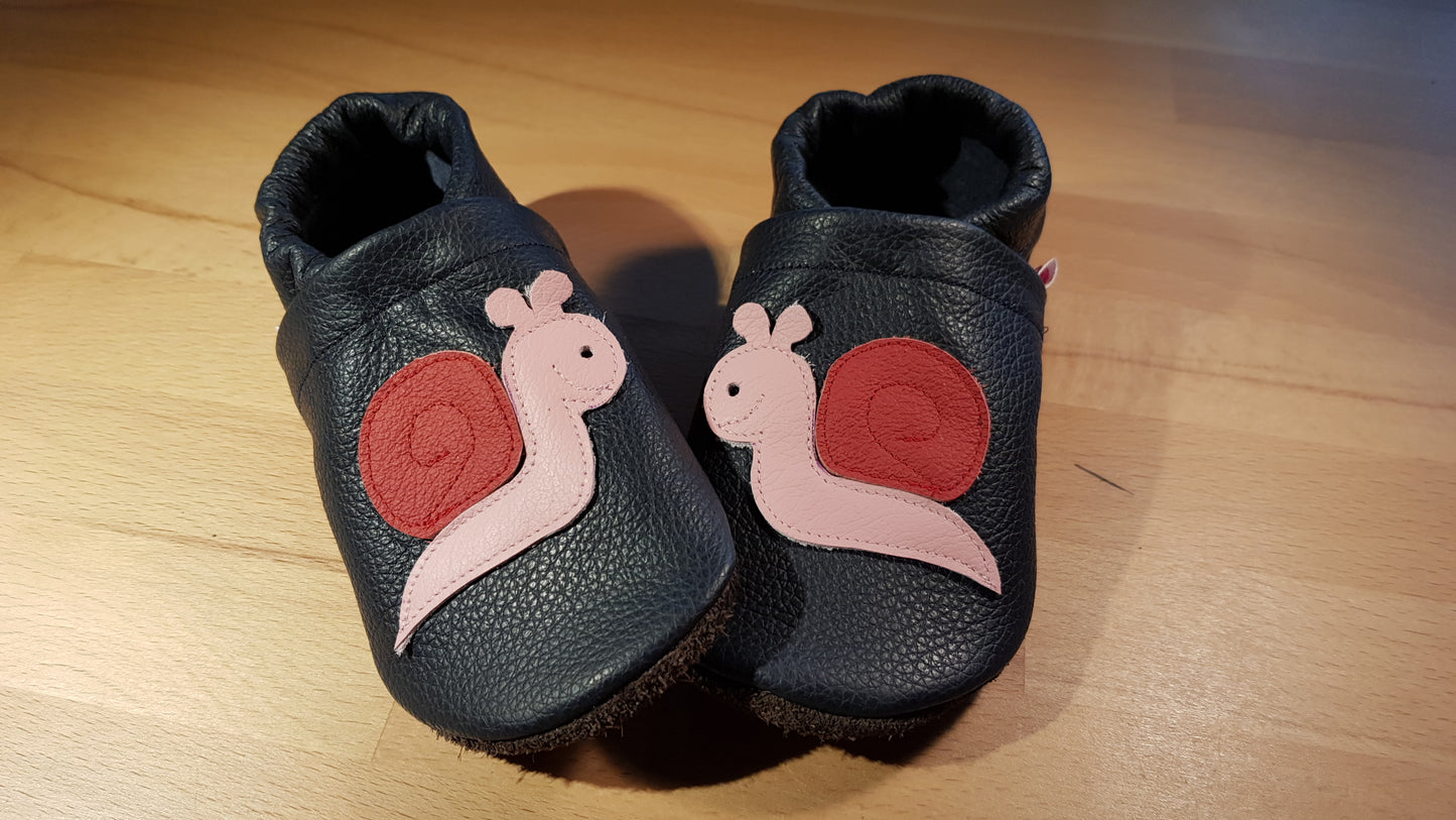 Dunkelblaue Lederpuschen mit einer rosa-weinroten Schnecke