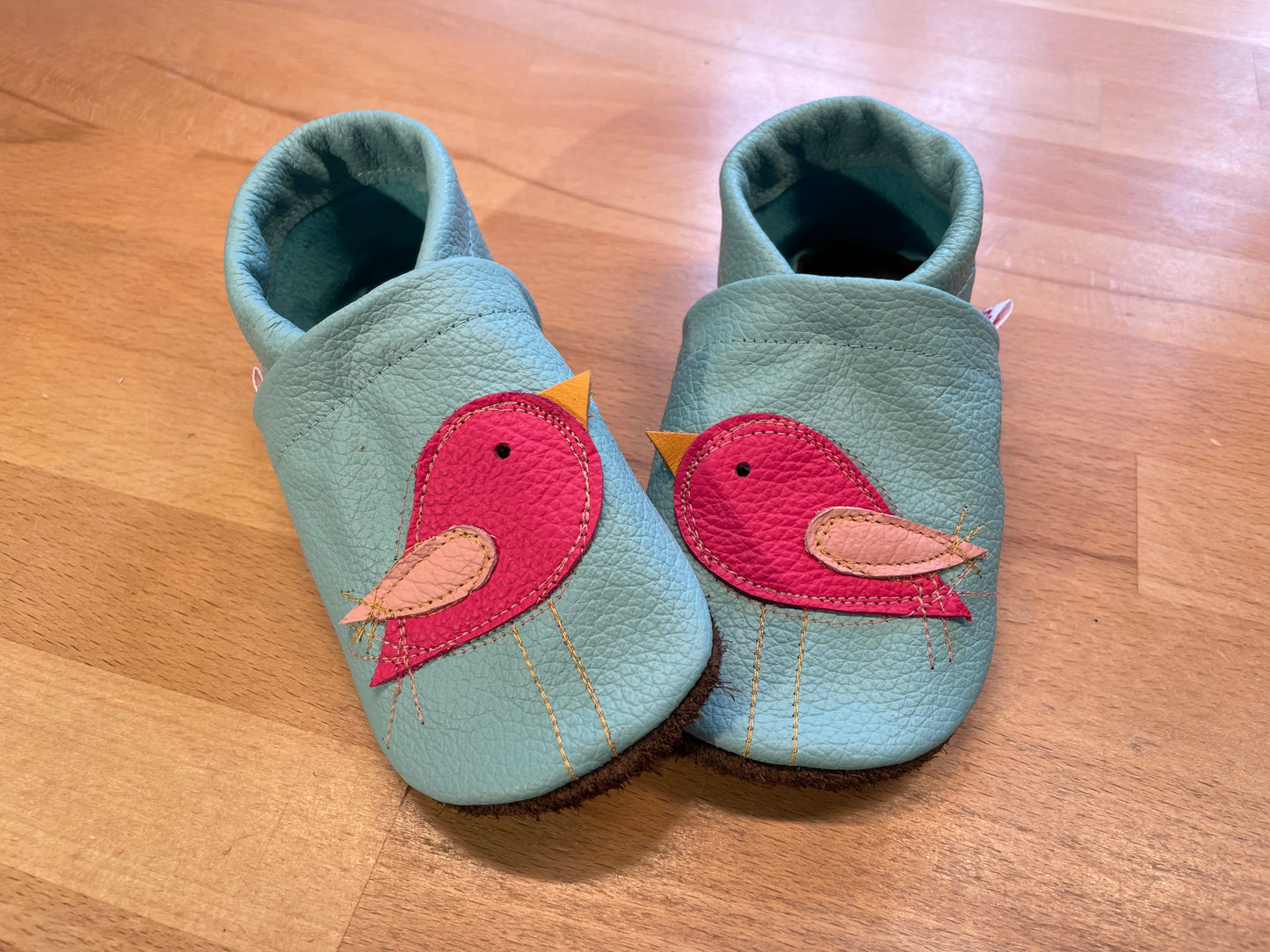 Hellblaue Lederpuschen mit pinkfarbenen Vögelchen