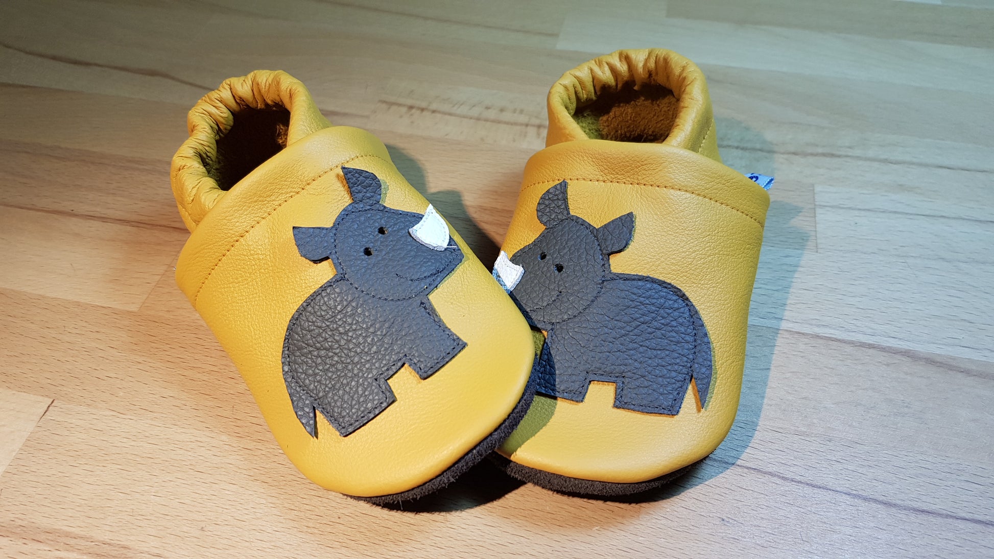 Gelbe Lederpuschen mit Nashörner