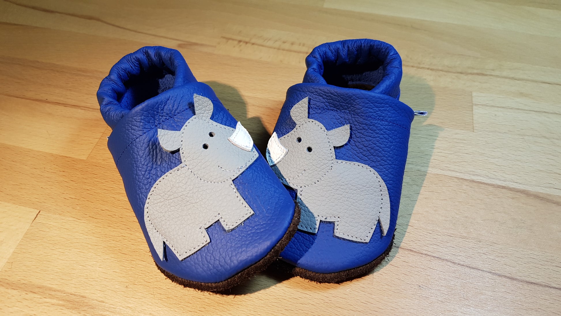 Capriblaue Lederpuschen mit Nashörner