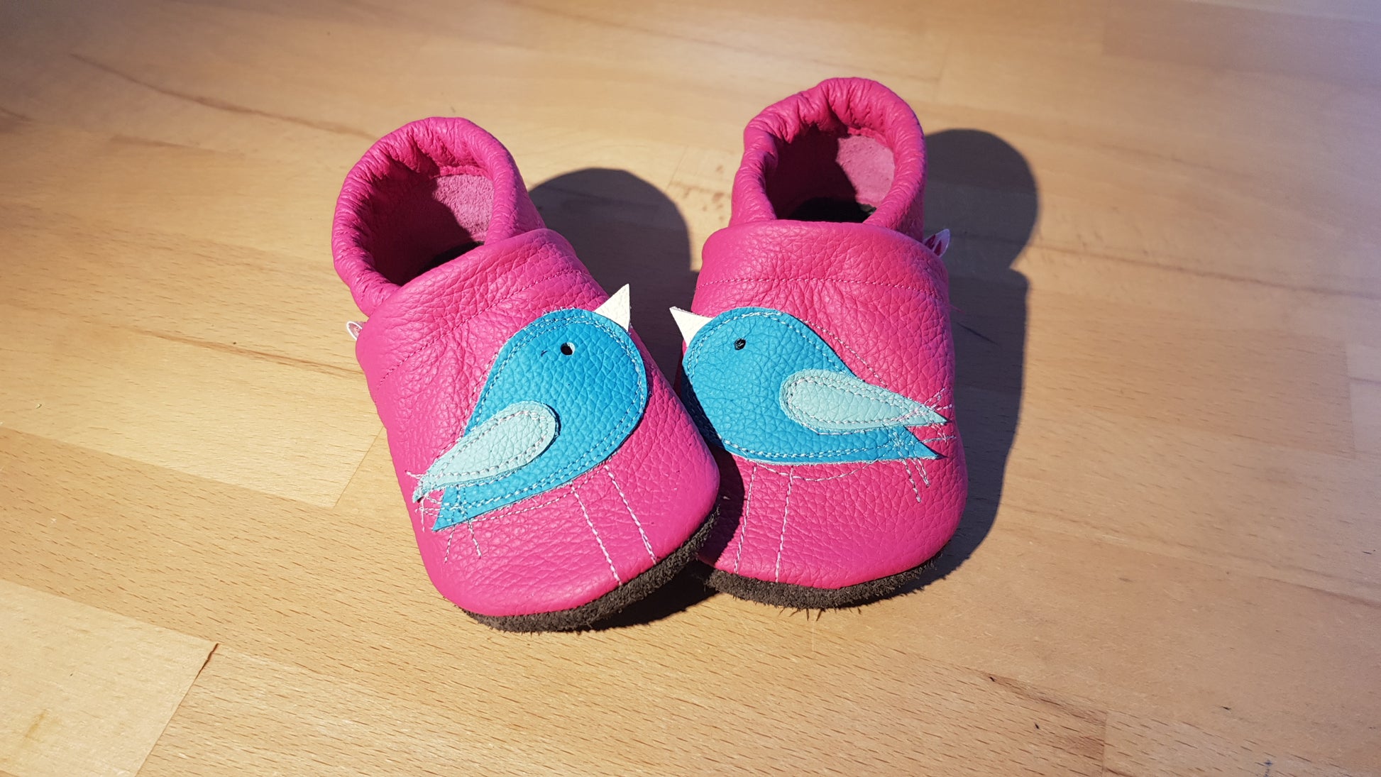 Pinkfarbene Lederpuschen mit türkisfarbenen Vögelchen